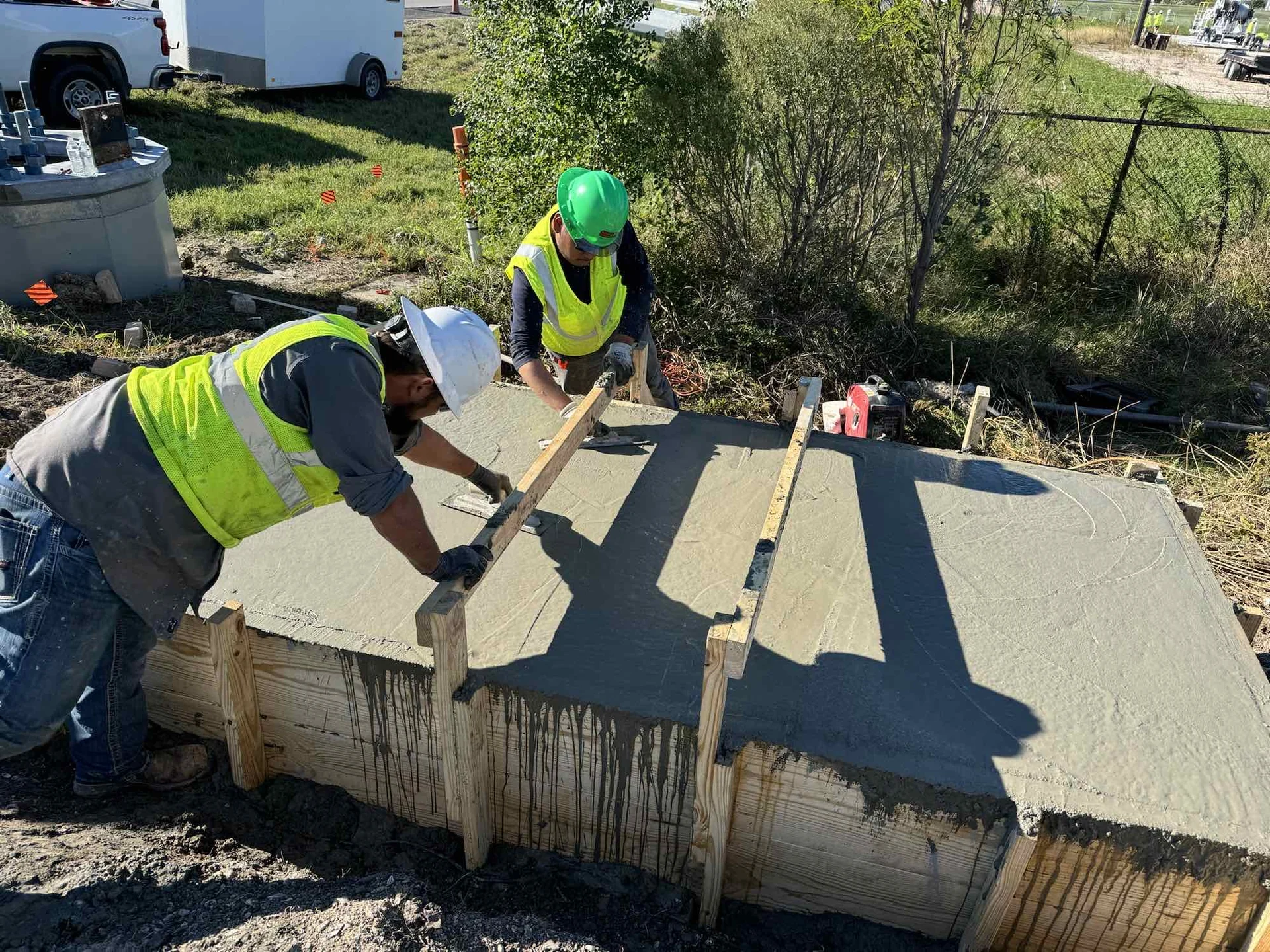 Crew finishing a concrete equipment foundation.