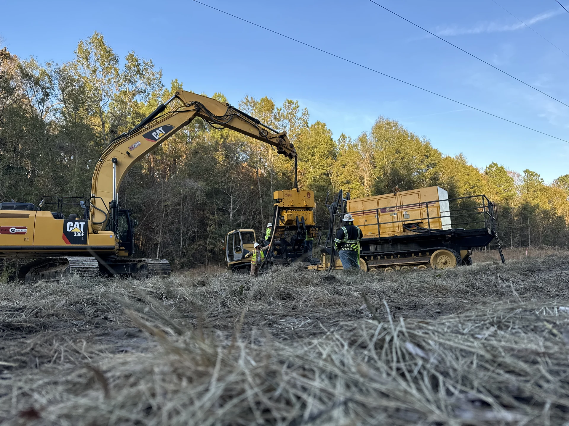 Vibratory pile installation with tracked equipment.